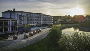 Un hotel de varios pisos con piscina y zona de estar al aire libre.