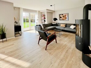 A spacious living room with a large sectional sofa, a coffee table, and a modern fireplace.