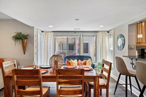 Comedor con una mesa de madera dispuesta para cuatro personas, rodeada de sillas.