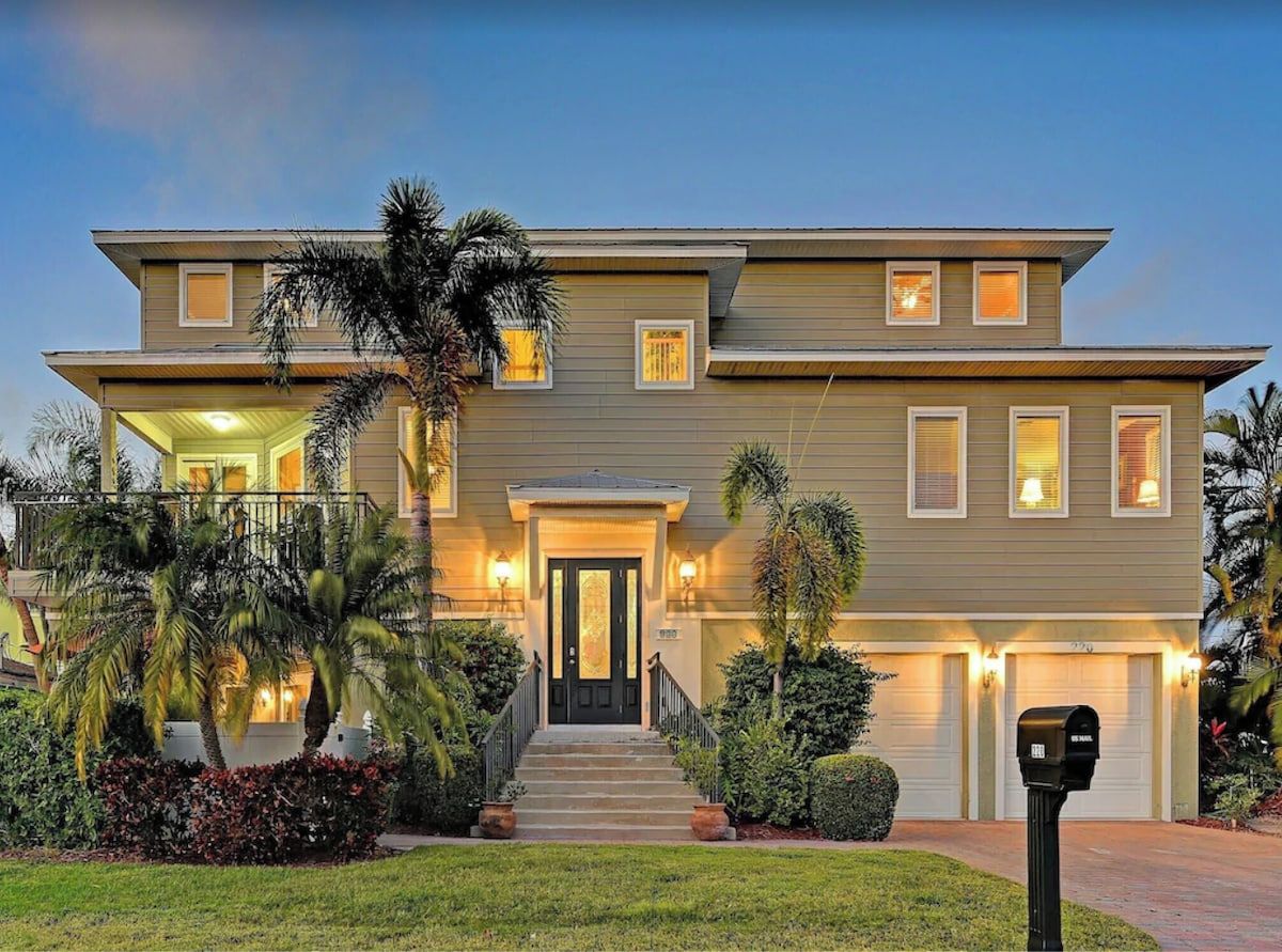 A two-story house with a front porch, a garage, and a well-maintained lawn.