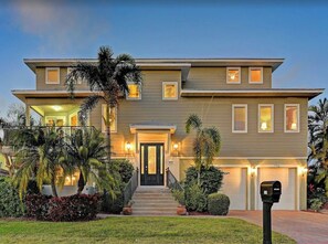 A two-story house with a front porch, a garage, and a well-maintained lawn.