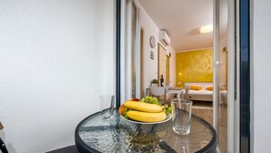 A small round table with a glass top, a plate of fruit, and two glasses. - Apartment and Studio Tereza (Rovinj)