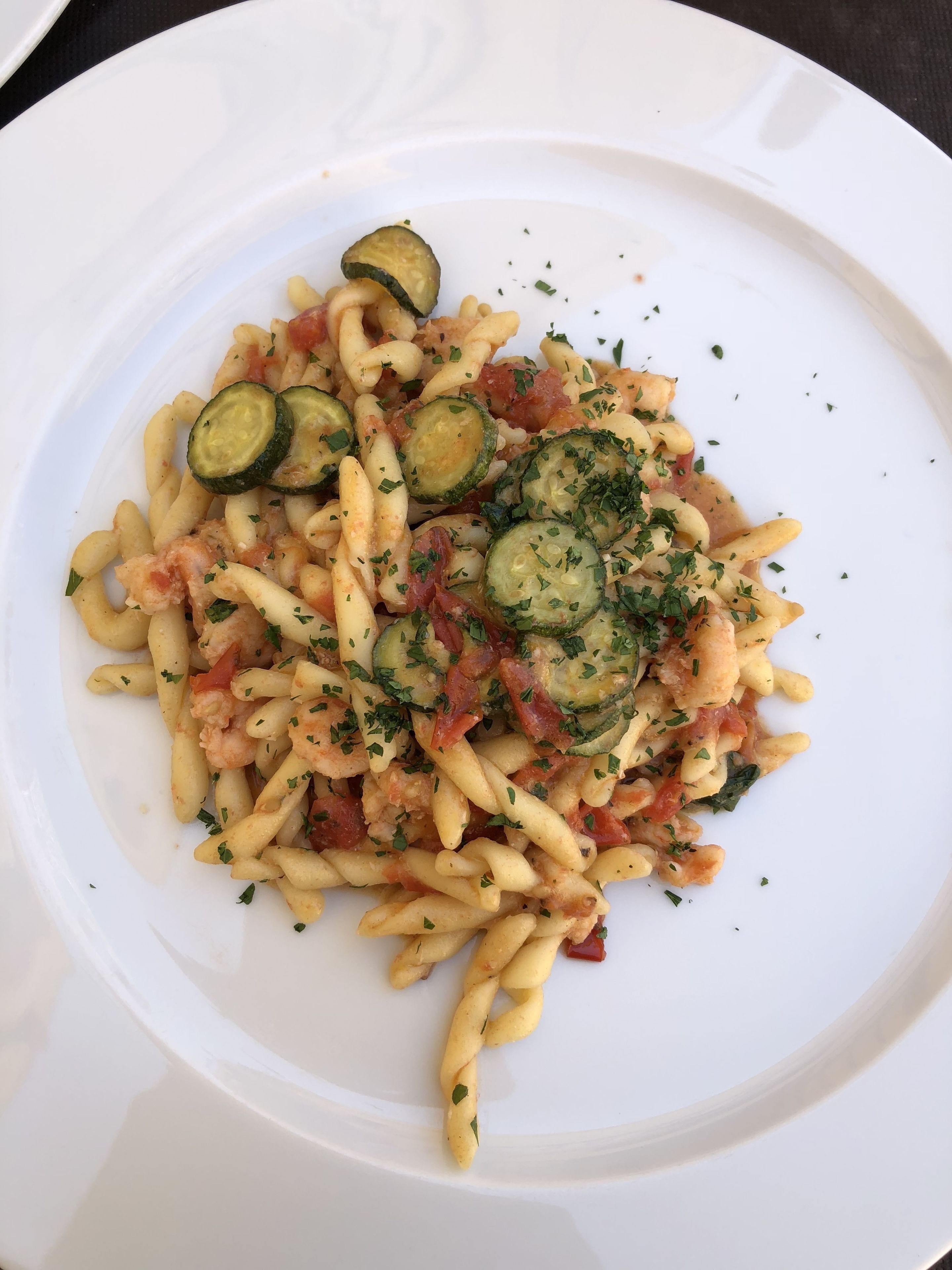 A plate of pasta with zucchini and herbs.