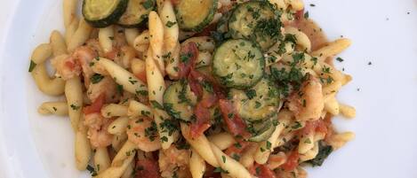 A plate of pasta with zucchini and herbs.