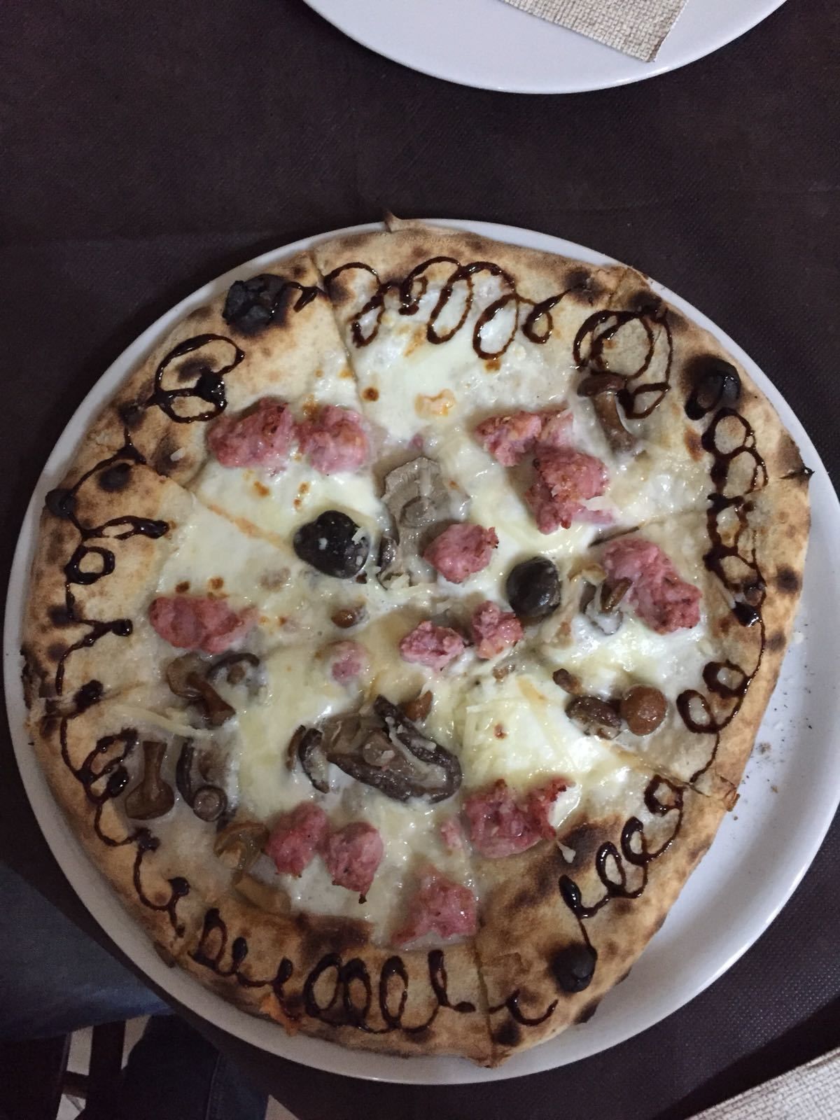 A pizza with various toppings on a white plate.