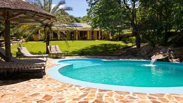 Alberca al aire libre y camastros