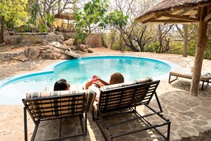 Una piscina al aire libre, tumbonas