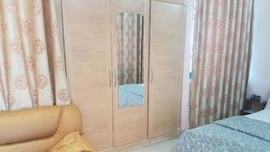 A bedroom with a bed, a wardrobe, and a sofa. - Blue Hill Hotel (Bamahu)