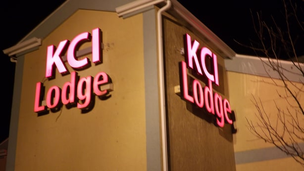 L’extérieur d’un bâtiment orné d’enseignes lumineuses au néon indiquant « KCI Lodge ».
