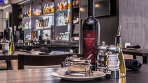 A bar area with a wine bottle, salt and pepper shakers, and a dessert on a plate.
