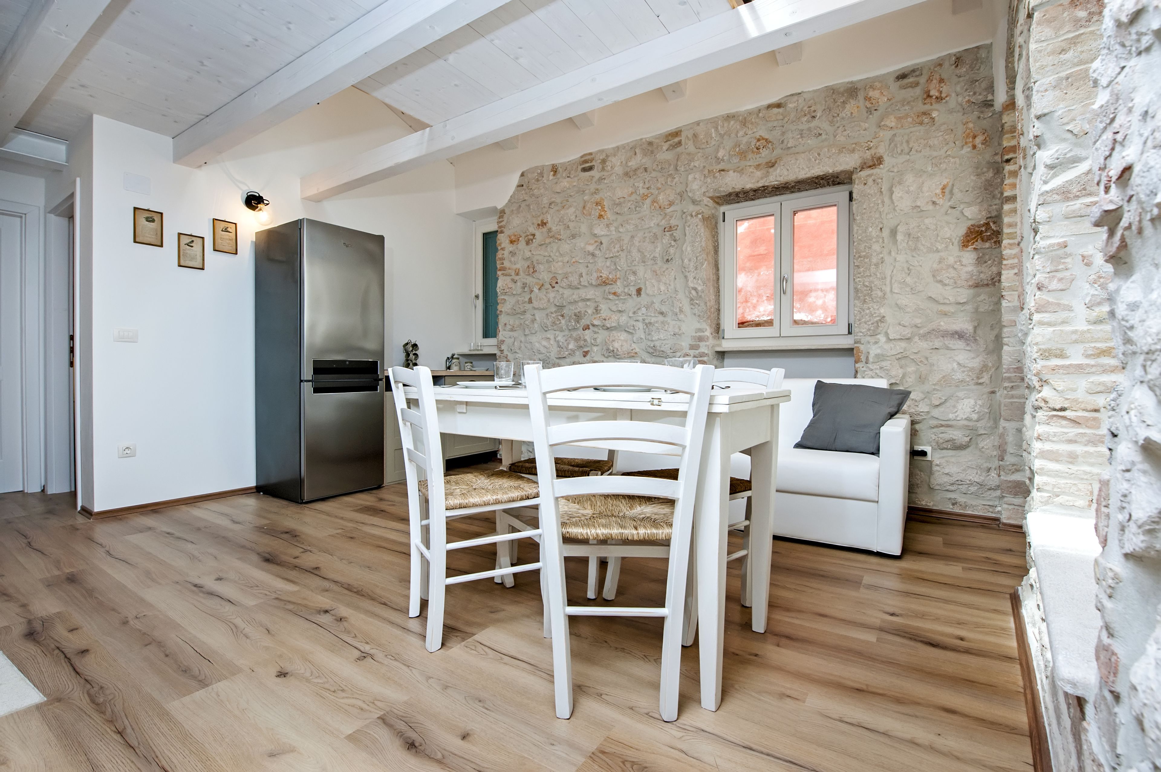 Un espacio habitable pequeño con comedor, kitchenette y pared de acento de piedra.