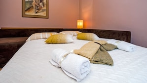 Una habitación de hotel con una cama grande, almohadas y un cuadro en la pared.