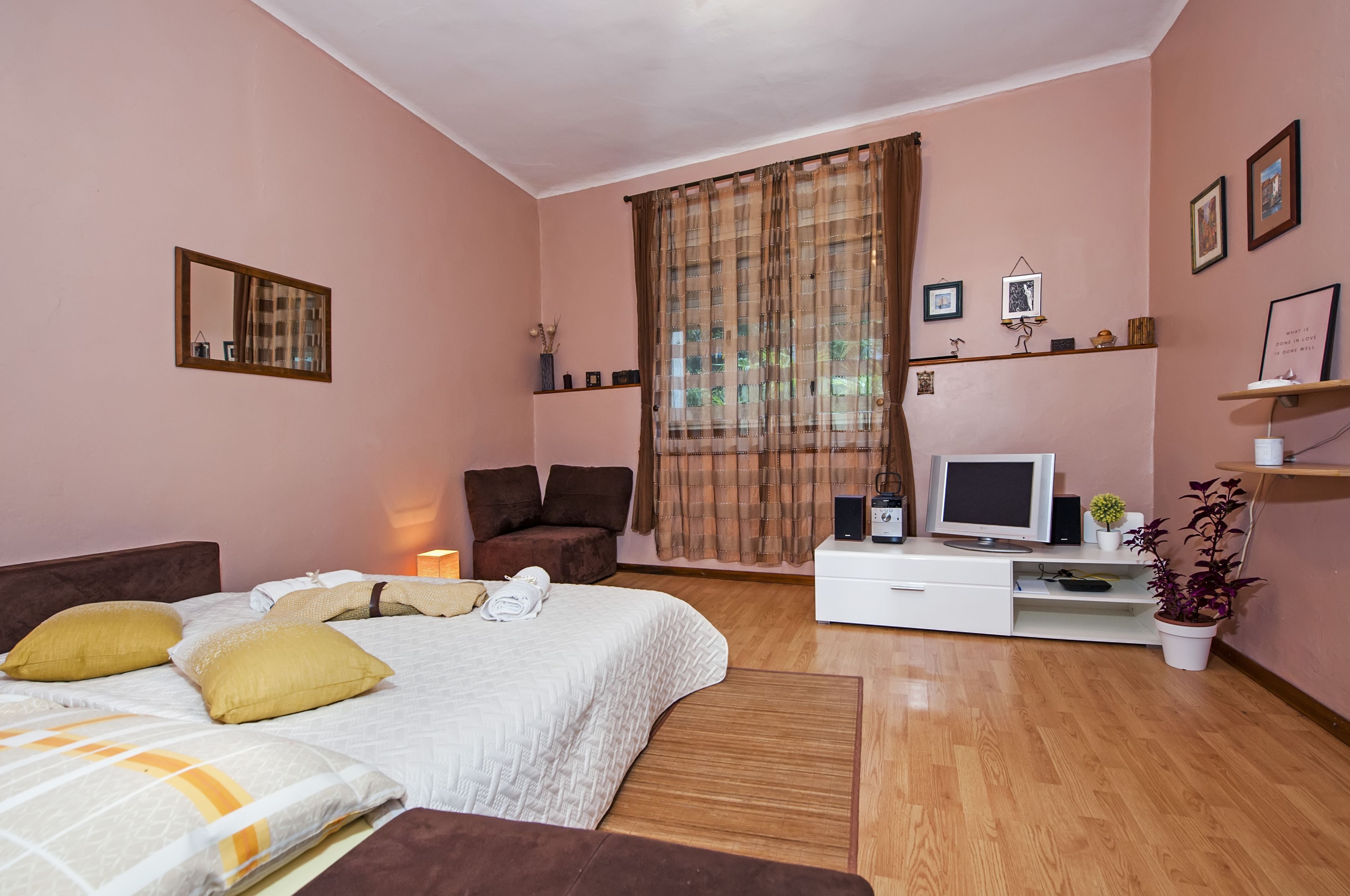 A bedroom with a bed, a TV, a desk, and a chair.
