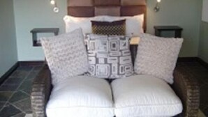 A bedroom with a large bed, two bedside tables, and a headboard with built-in lighting. - Mount Lodge Humewood (Gqeberha (Port Elizabeth))