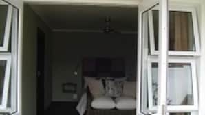 A bedroom with a bed, a window, and a door. - Mount Lodge Humewood (Gqeberha (Port Elizabeth))