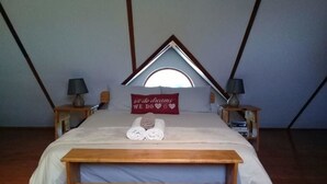 A bedroom with a bed, two bedside tables, a pillow with a message, and a window. - Lady Grey Walk Cottage (McGregor)