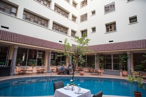 Una piscina al aire libre de temporada, sombrillas