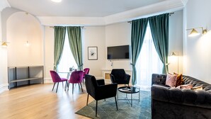 Un salon moderne avec un canapé, des fauteuils, un téléviseur et une cheminée.