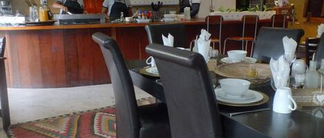 Ein Restaurant mit einer Holztheke, schwarzen Stühlen und einer Uhr an der Wand.