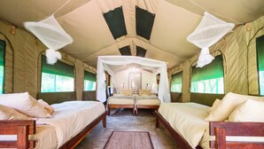 A tented accommodation with two wooden beds, mosquito nets, and a central walkway. - Zambezi Mubala Camp (Katima Mulilo)