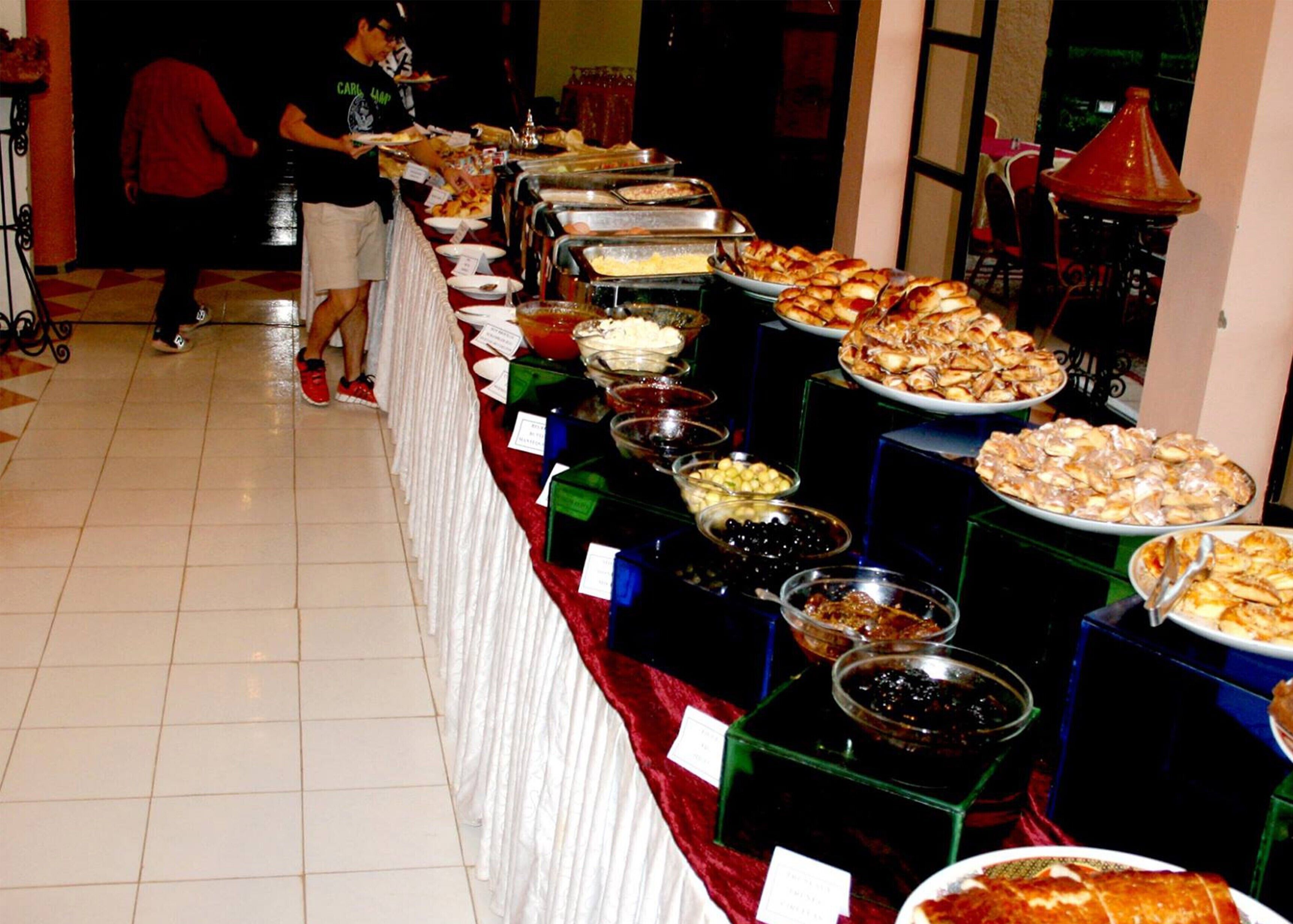 A buffet setup with various food items and containers.