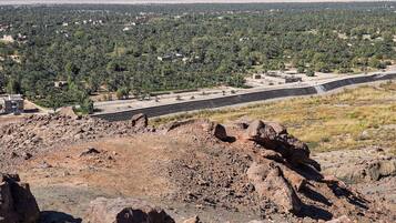 A desert landscape with a road, rocky terrain, and scattered buildings.