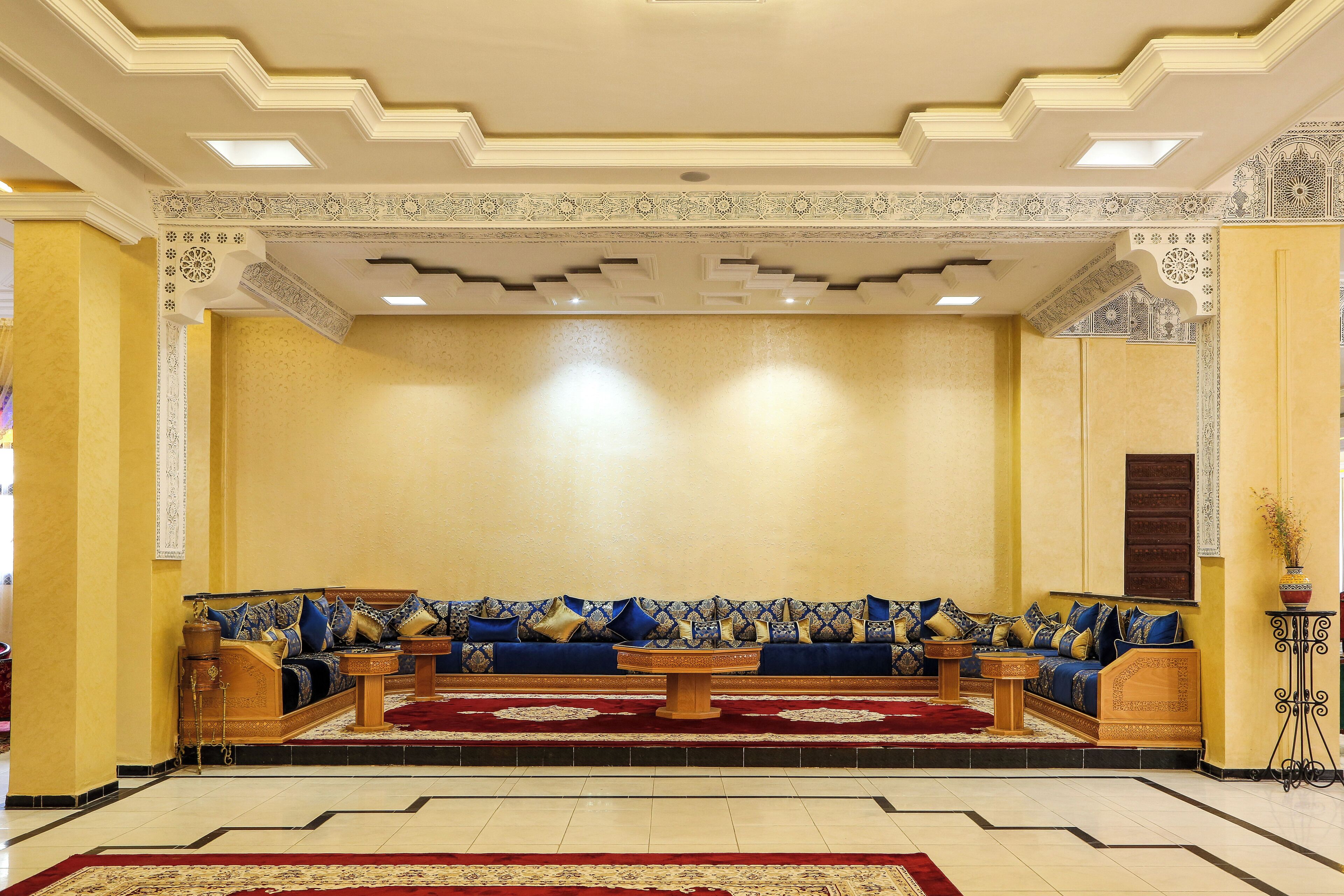 A spacious lobby with a large sofa set, a coffee table, and a patterned rug.