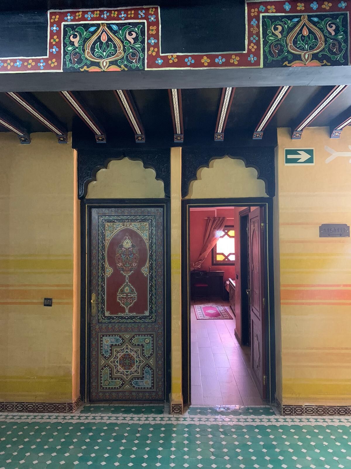 A hallway with ornate doors and a patterned floor.