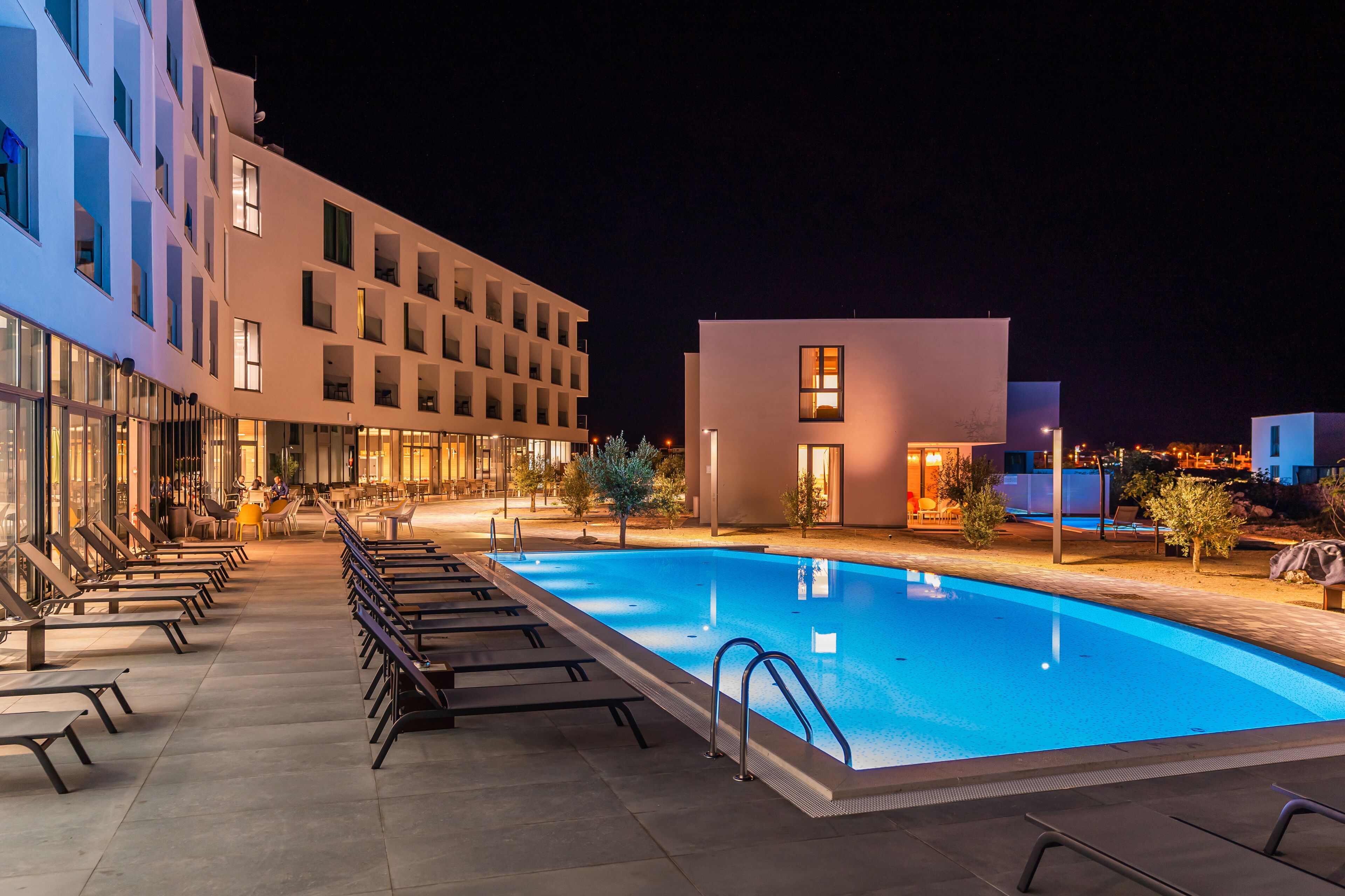 Een binnenzwembad, een buitenzwembad, parasols voor strand/zwembad