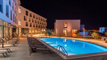 Een binnenzwembad, een buitenzwembad, parasols voor strand/zwembad