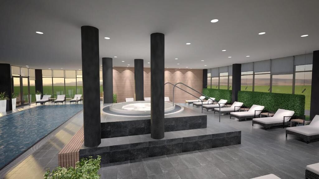Uma área interna de piscina moderna, com espreguiçadeiras, hidromassagem e vista para o exterior.