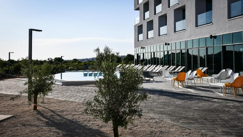 Un edificio moderno con piscina y zona de estar al aire libre.