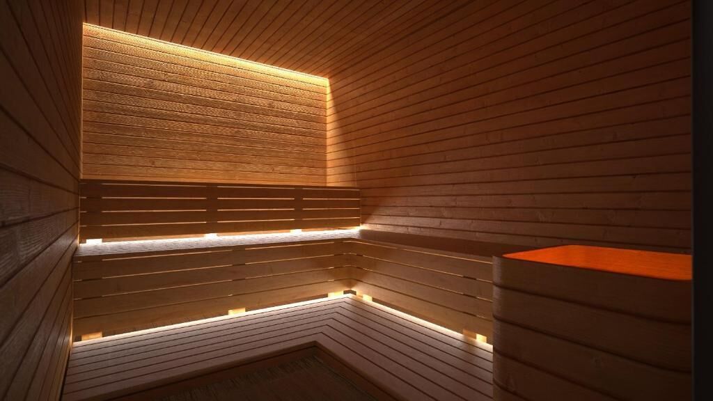 Una sauna con listones de madera e iluminación integrada.