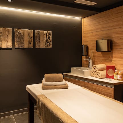 A modern bathroom with a wooden wall, a sink, and a towel rack.