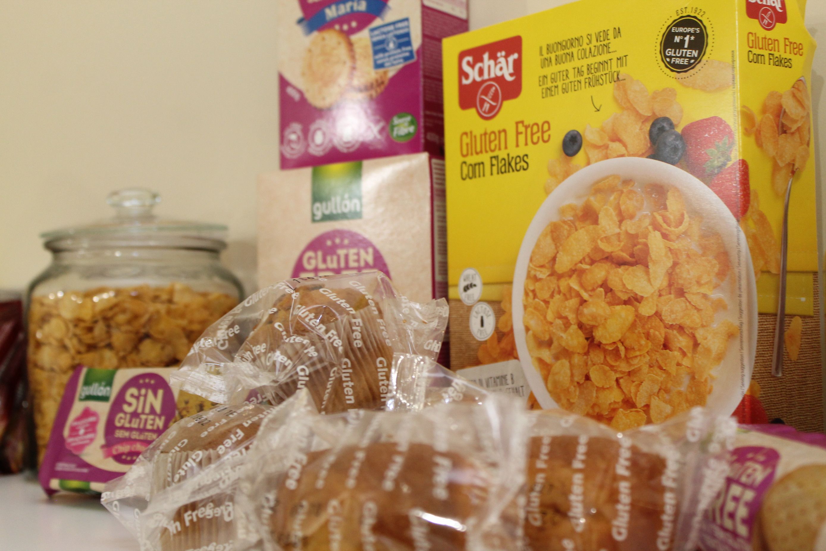 Glutenvrije cornflakes pakken, een pot cornflakes en glutenvrij brood.