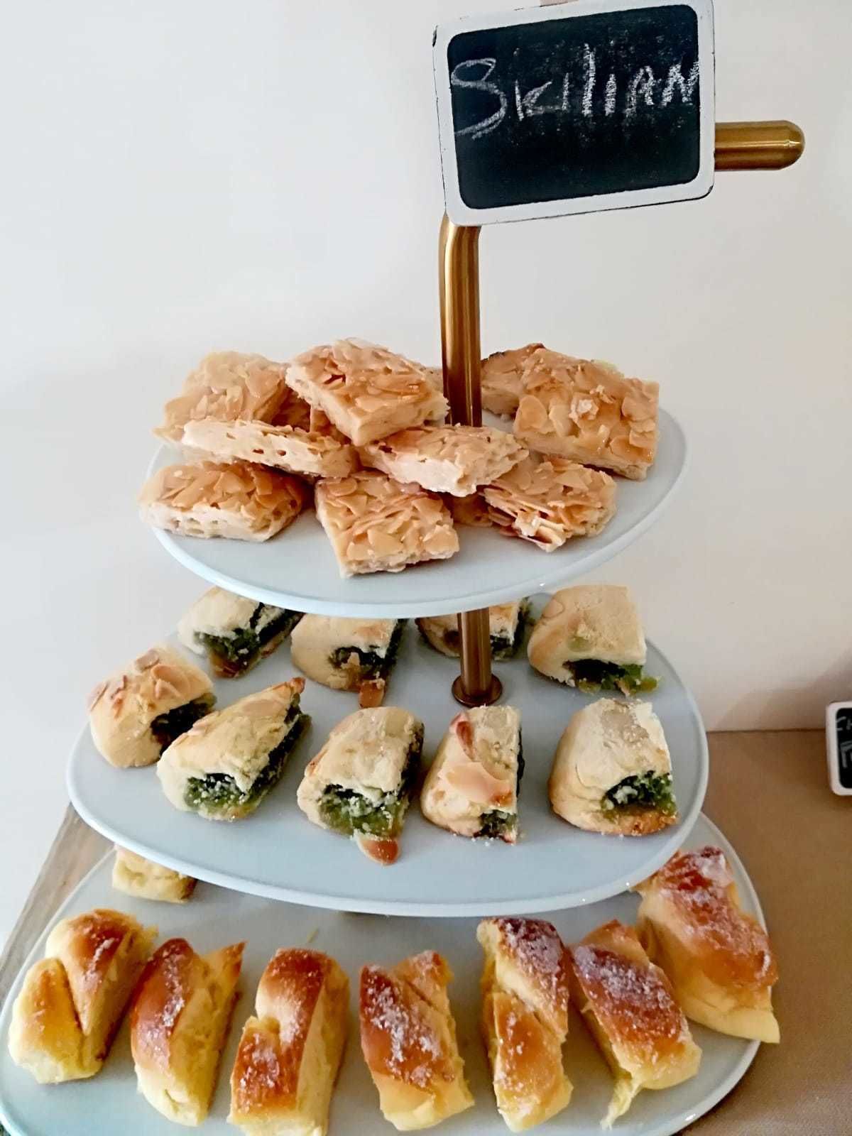 A three-tiered dessert display with various pastries.