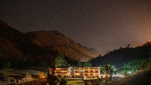 A hotel with multiple floors, situated in a valley with mountains in the background. - Tambo Lodge Canta (Canta)