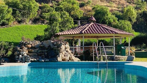 A swimming pool with a gazebo, surrounded by a mountainous landscape. - Tambo Lodge Canta (Canta)