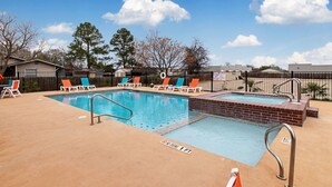 A swimming pool with lounge chairs, a brick deck, and a fence. - Comfort Inn and Suites (Fredericksburg)