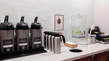 En kaffestation med flera kaffedispensrar, en vattendispenser och en kaffemaskin.