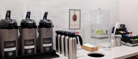 A coffee station with multiple coffee dispensers, a water dispenser, and a coffee machine.