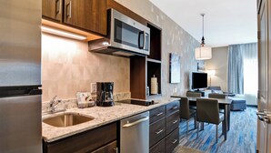 Una cocina moderna con microondas integrado, refrigerador de acero inoxidable y cafetera.
