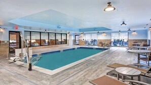 Una piscina interior con vista despejada al área de la piscina, un letrero que indica 'No buceo' y un letrero que dice 'Salida'.