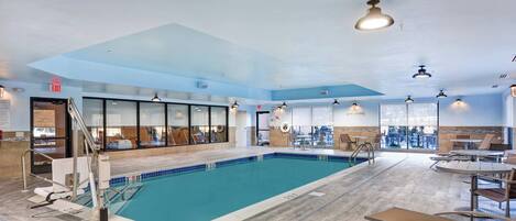 An indoor swimming pool with a clear view of the pool area, a 'No Diving' sign, and a 'Exit' sign.