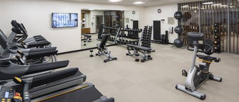 A gym with treadmills, weight machines, and free weights.