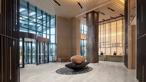 A spacious lobby with a modern design, featuring a central sculptural element, large glass windows, and a reception desk. - Courtyard by Marriott Jiangsu Taizhou (Taizhou)