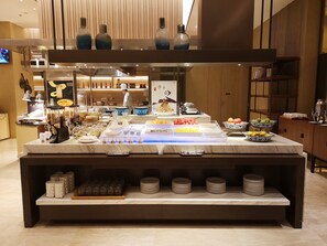 A buffet setup with various food items and condiments. - Courtyard by Marriott Jiangsu Taizhou (Taizhou)