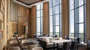 A spacious hotel lobby with high ceilings, large windows offering a view of the city, and a mix of seating arrangements including sofas and tables. - Courtyard by Marriott Jiangsu Taizhou (Taizhou)