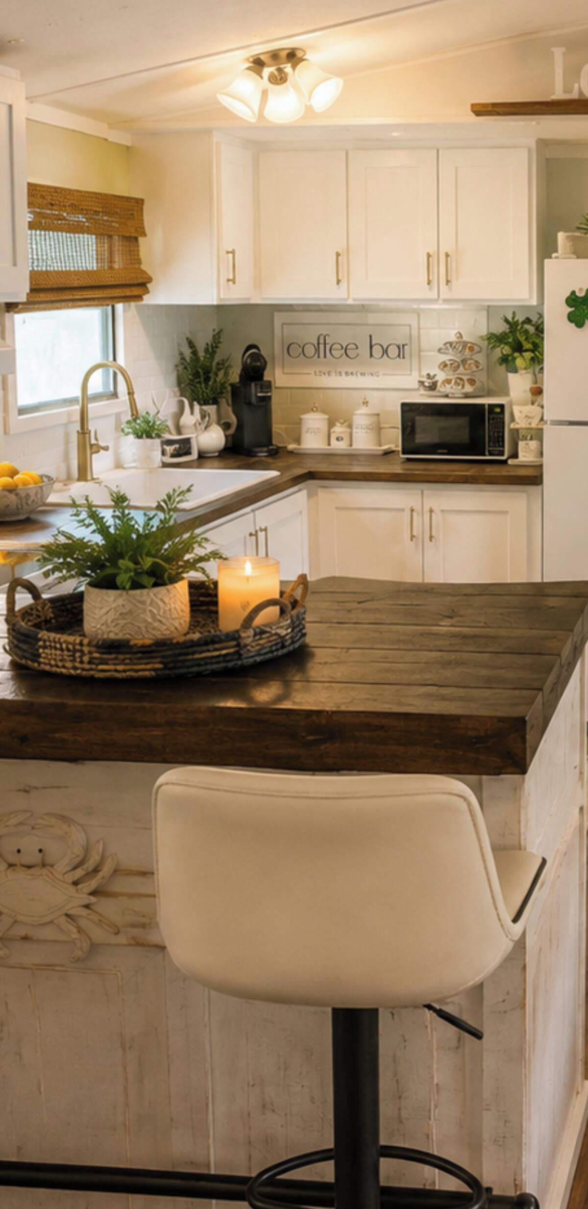 A kitchen with white cabinets, a coffee bar sign, a microwave, and a bar stool.