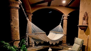 A cozy outdoor seating area with a hammock, a chair, and a table. - MALIBU LUXURY BEACH VILLA - 5-STAR REVIEWS! (Malibu)